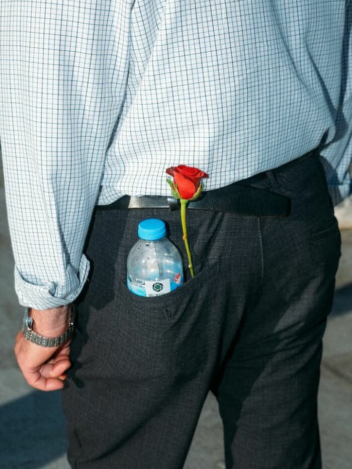 Una rosa y una botella de agua en el bolsillo en escenas callejeras.