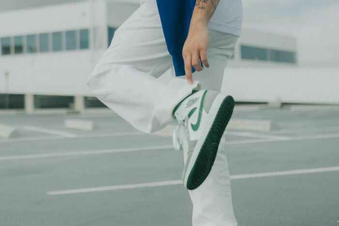Persona vistiendo zapatos deportivos y pantalones blancos en azotea