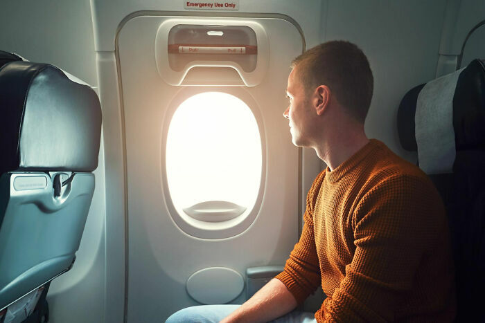 Pasajero mirando por la ventana del avión