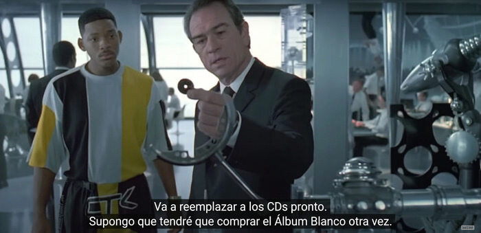 Escena de película con diálogo sobre reemplazo de CDs y álbum blanco