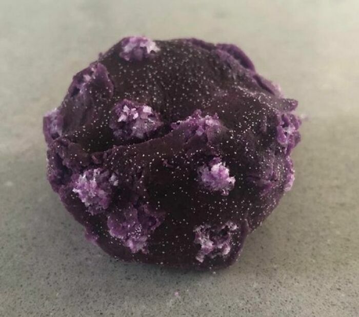 Mineral púrpura con cristales salinos en superficie rugosa