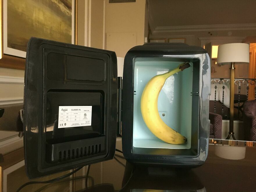 Mini refrigerador con una banana adentro en habitación de hotel