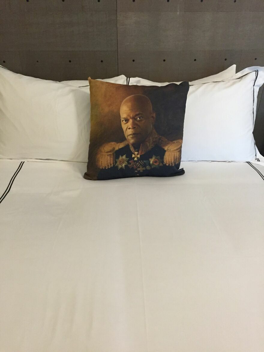 Almohada con retrato extraño en cama de hotel o Airbnb