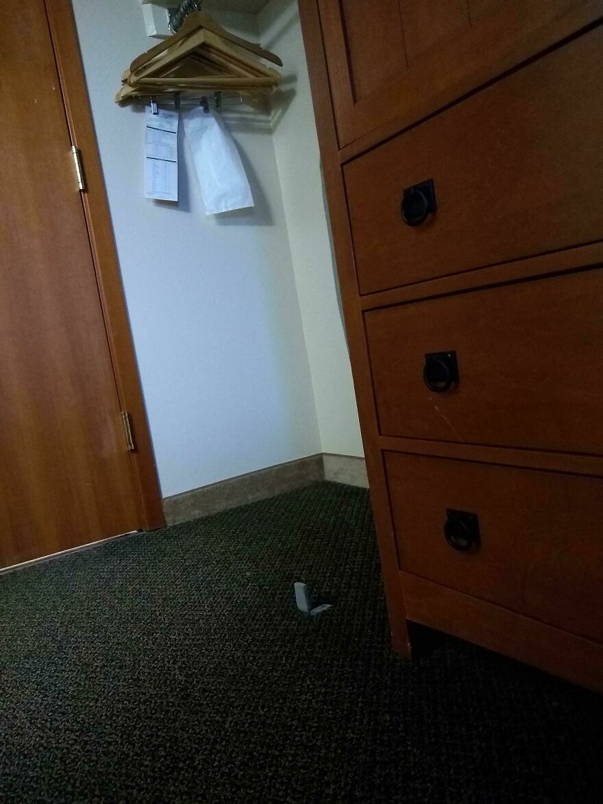 Papel higiénico tirado en el suelo junto a mueble en hotel o Airbnb