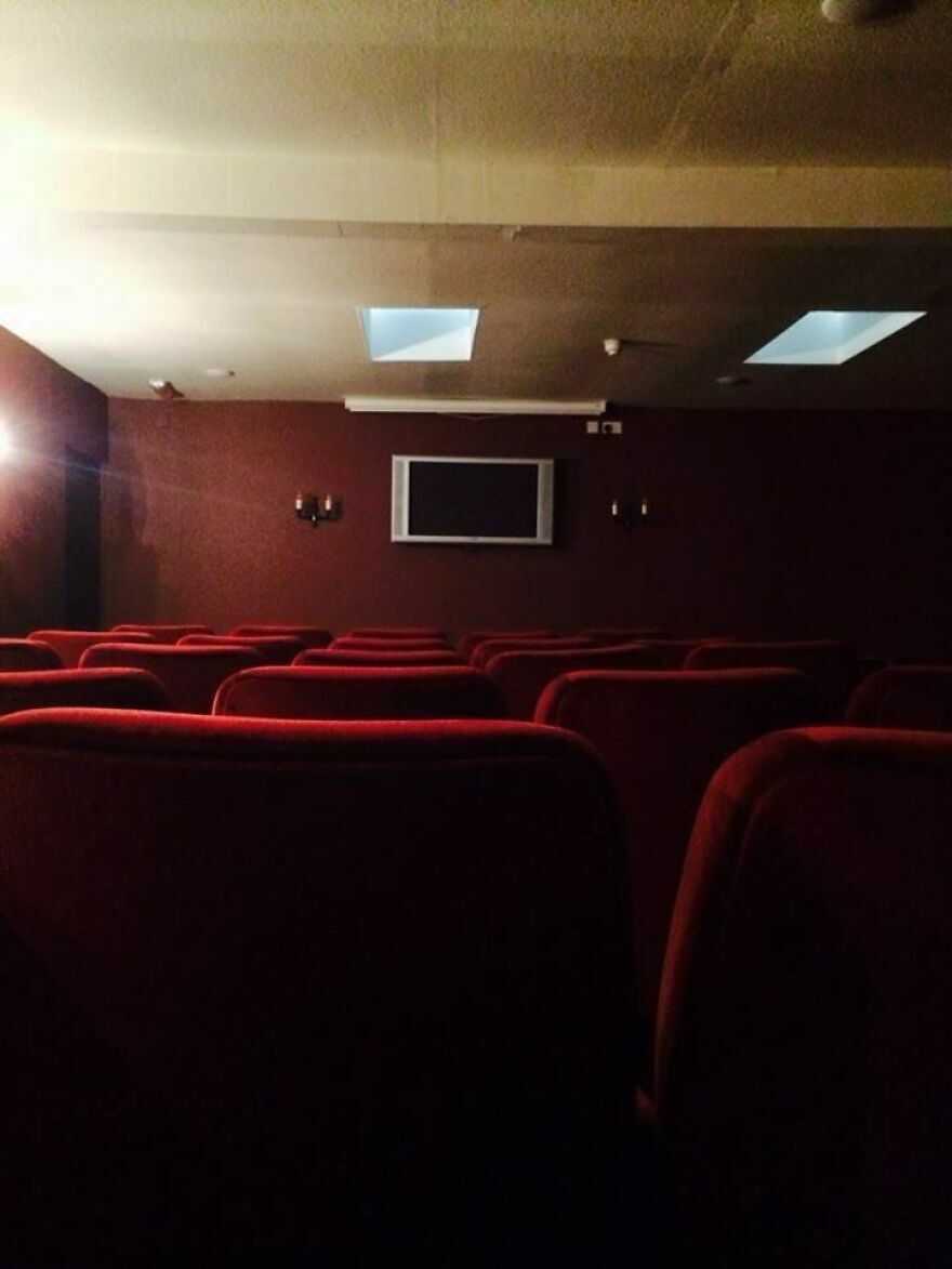Sala de cine oscura con iluminación deficiente en hotel Airbnb