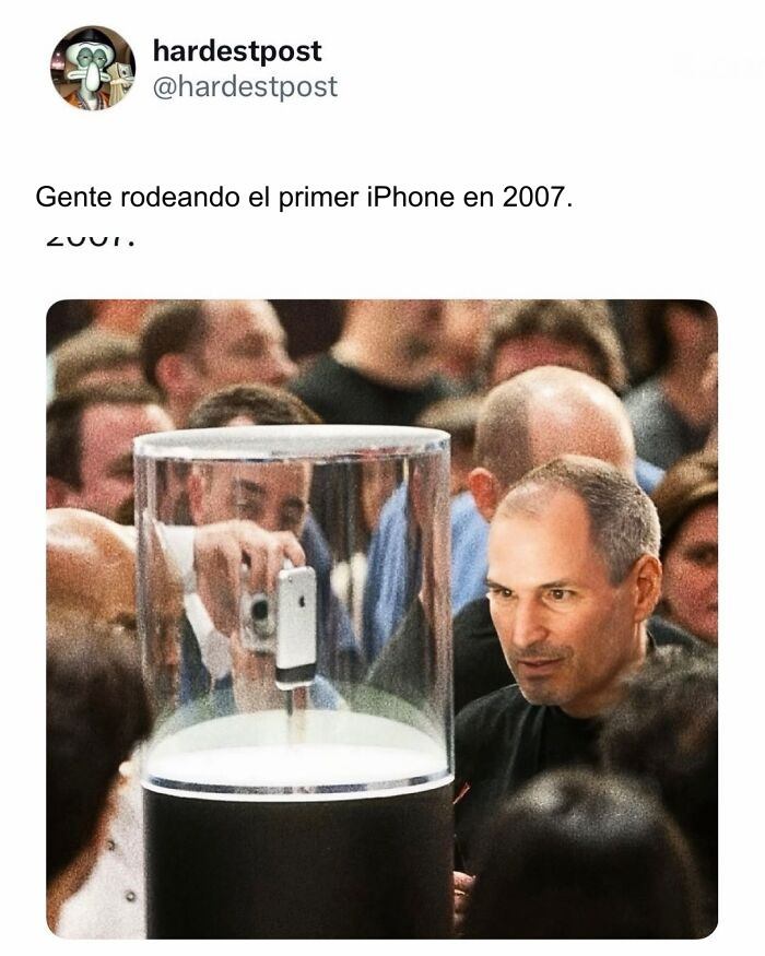 Multitud viendo el primer iPhone presentado en 2007 en una vitrina.