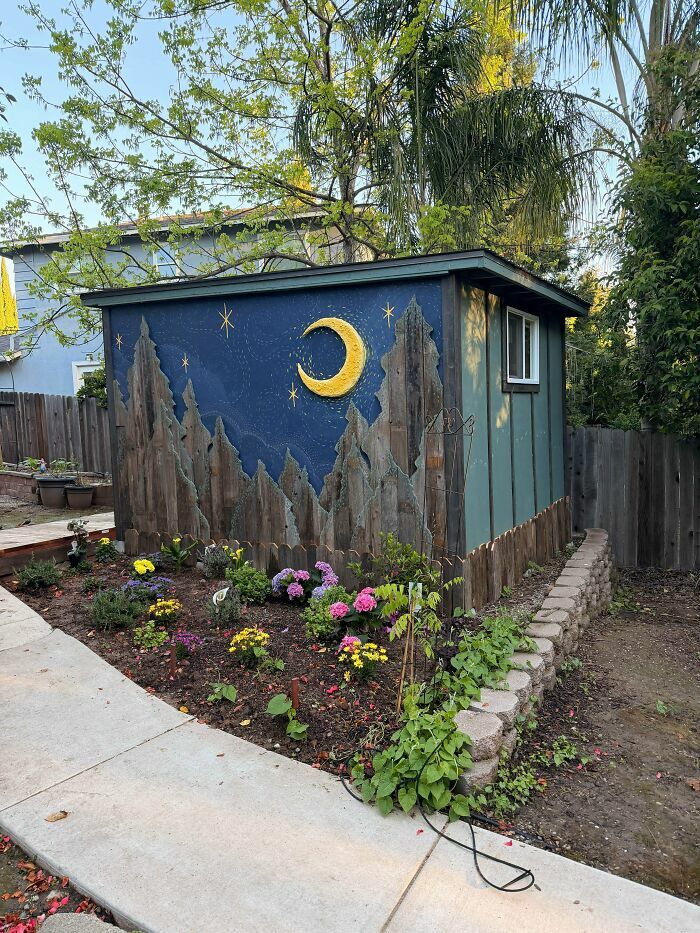 Decoración exterior con mural de luna y estrellas en jardín con plantas