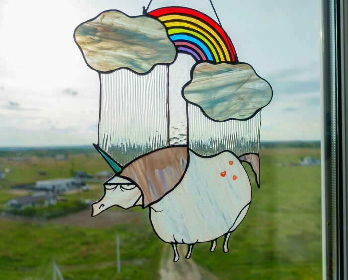 Vidriera artística con diseño de unicornio y arcoíris colgante en ventana