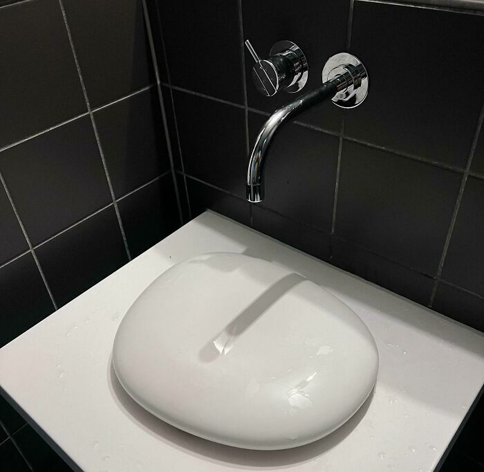 Lavabo moderno con diseño confuso que impide uso correcto del grifo en fallos de diseño divertidos