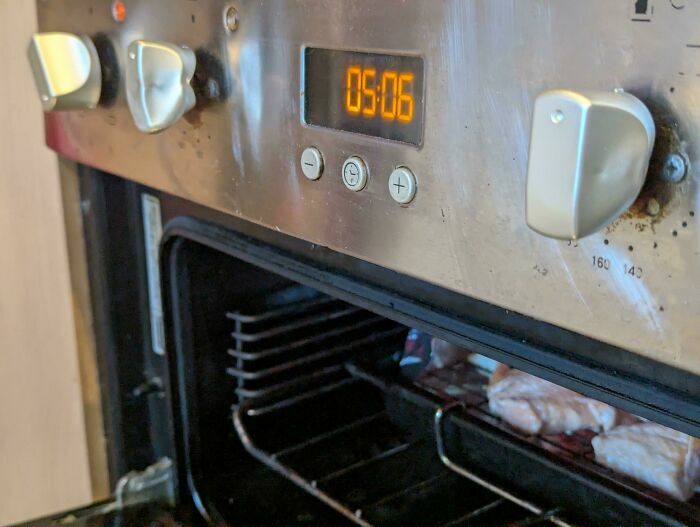 Horno con botón agrietado y óxido visible, ejemplo de fallo de diseño
