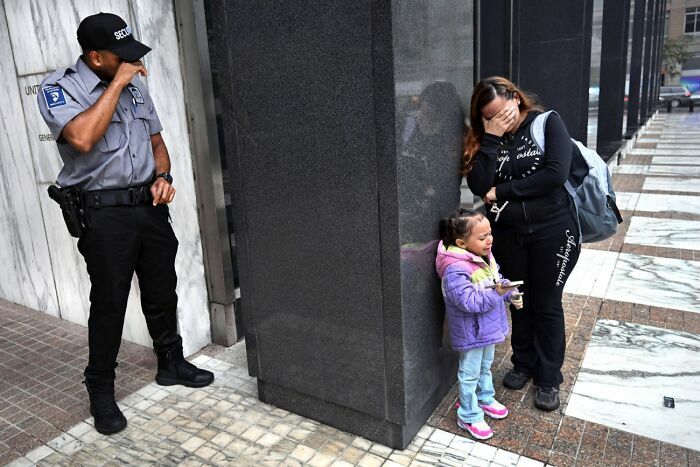 Mujer y niña llorando con guardia de seguridad en ciudad fotografía Siena 2026