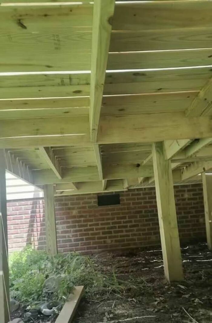 Estructura de madera mal apoyada en ladrillos, un claro ejemplo de fallos de construcción.