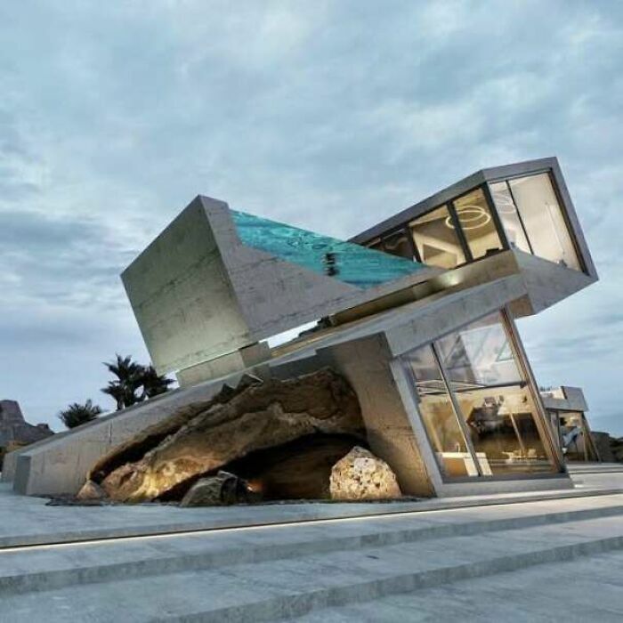 Estructura futurista inclinada de concreto y vidrio con evidentes fallos de construcción.
