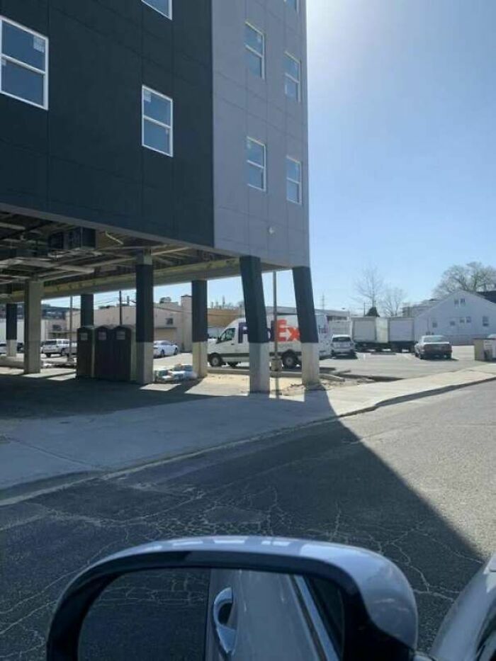 Edificio moderno sostenido por columnas inclinadas que muestran preocupantes fallos de construcción.