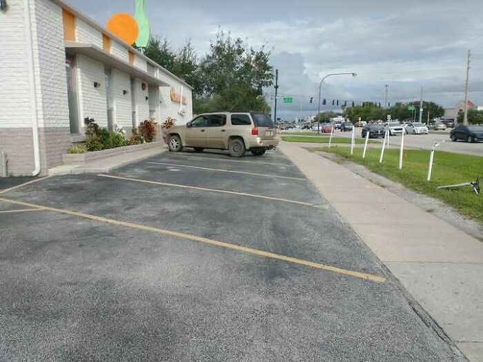 Líneas de estacionamiento mal pintadas en la acera, un absurdo fallo de construcción.