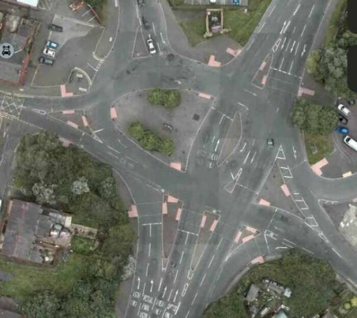 Vista aérea de una intersección vial caótica con marcas confusas, un claro ejemplo de fallos de construcción.