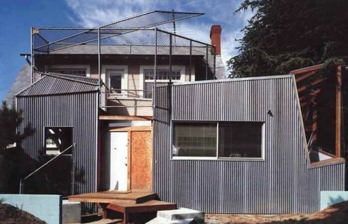 Casa con fachada de metal corrugado e inusuales jaulas en el techo, evidenciando extraños fallos de construcción.
