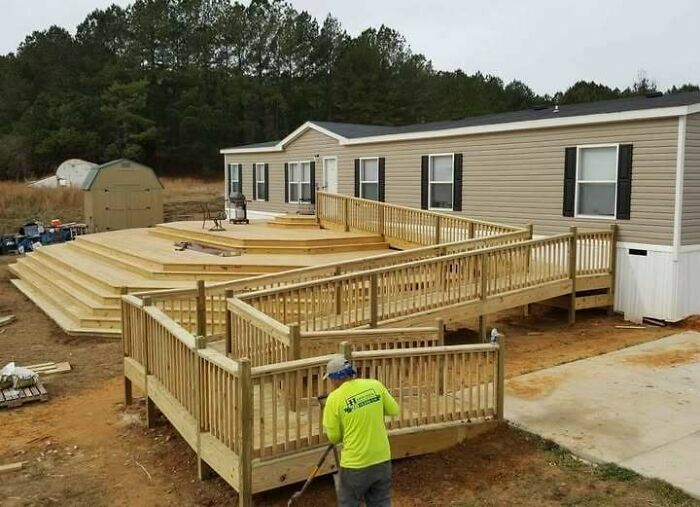 Rampa de madera exageradamente larga frente a una casa, una rampa absurda por fallos de construcción.
