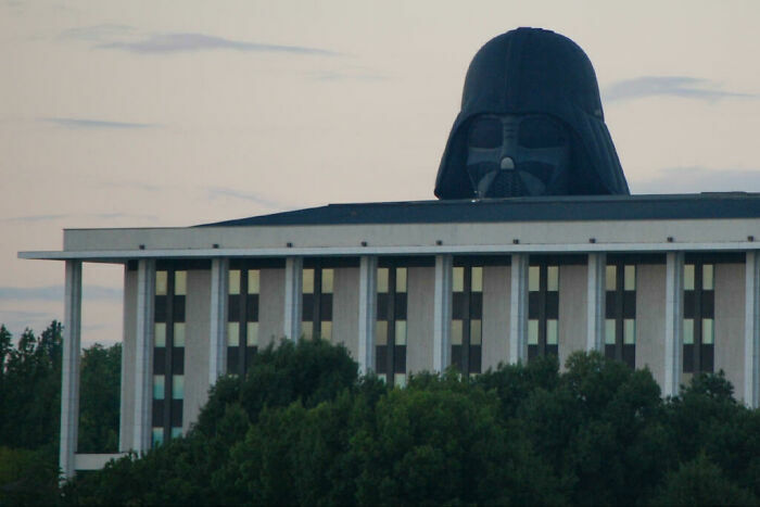 Divertidas fotos de la cabeza de Darth Vader asomándose detrás de un edificio moderno.