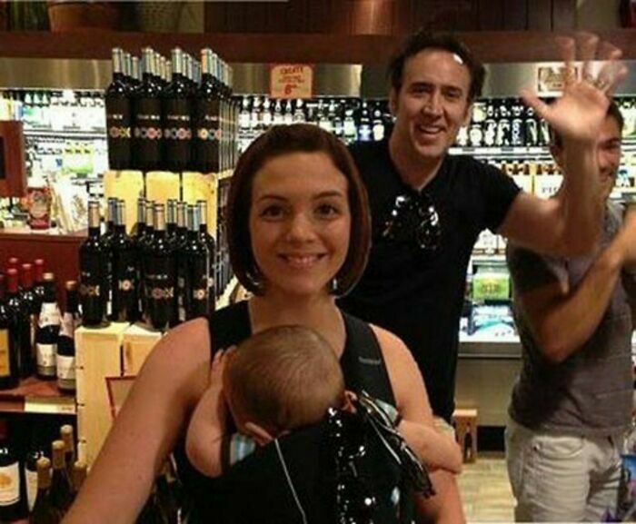 Nicolas Cage posando al fondo de una foto familiar, una de esas fotos divertidas.