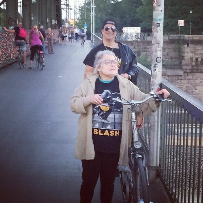 Músico Slash caminando detrás de una fan en la calle, fotos divertidas.