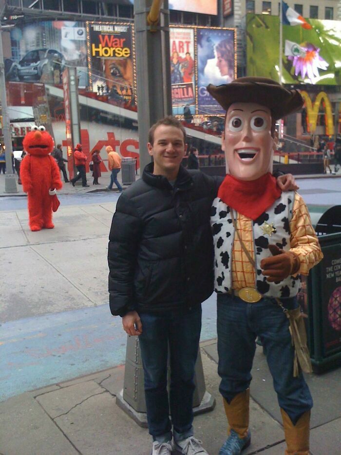 Un hombre junto a Woody en Times Square mientras Elmo camina al fondo en una de estas divertidas fotos.