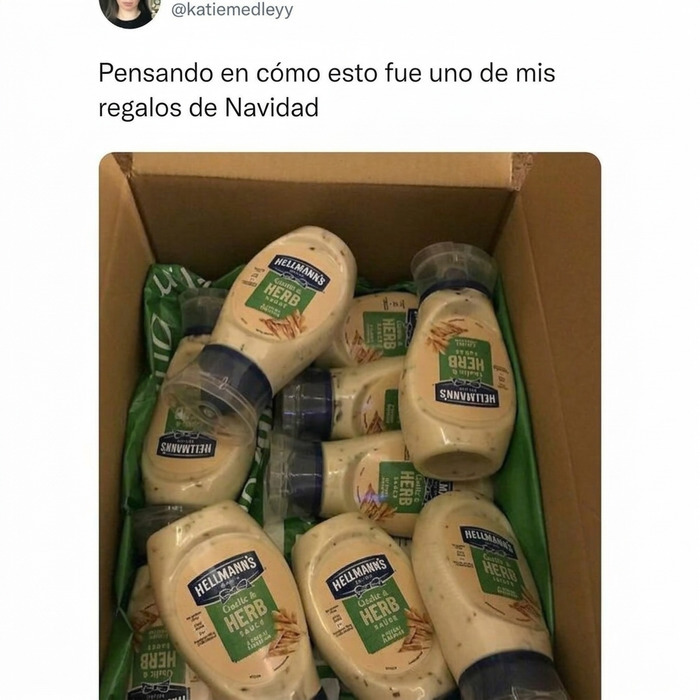 Una caja llena de botes de salsa de ajo y hierbas, ilustrando memes británicos sobre regalos de Navidad.
