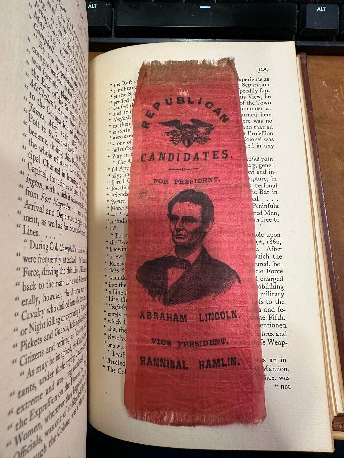 Marcapáginas de tela de Abraham Lincoln como ejemplo de objetos efímeros históricos dentro de un libro.