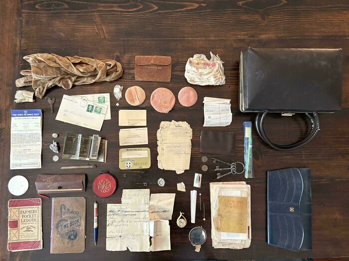 Colección de objetos efímeros antiguos sobre una mesa de madera como cartas, bolsos y documentos.