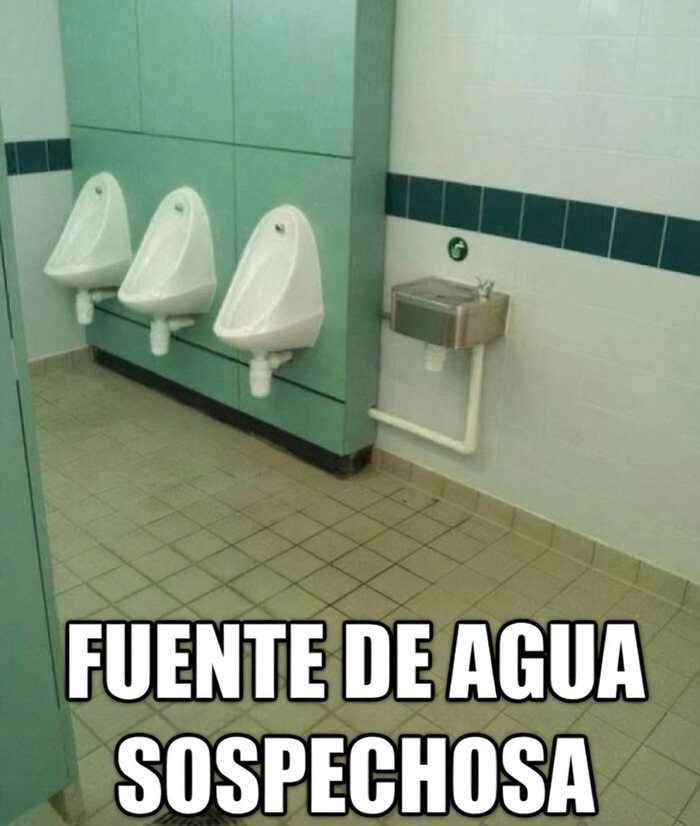 Meme sobre construcción que muestra un bebedero mal instalado junto a los urinarios de un baño.