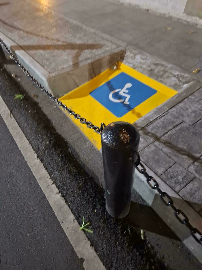 Rampa de accesibilidad para discapacitados bloqueada por una cadena, grave fallo de diseño.