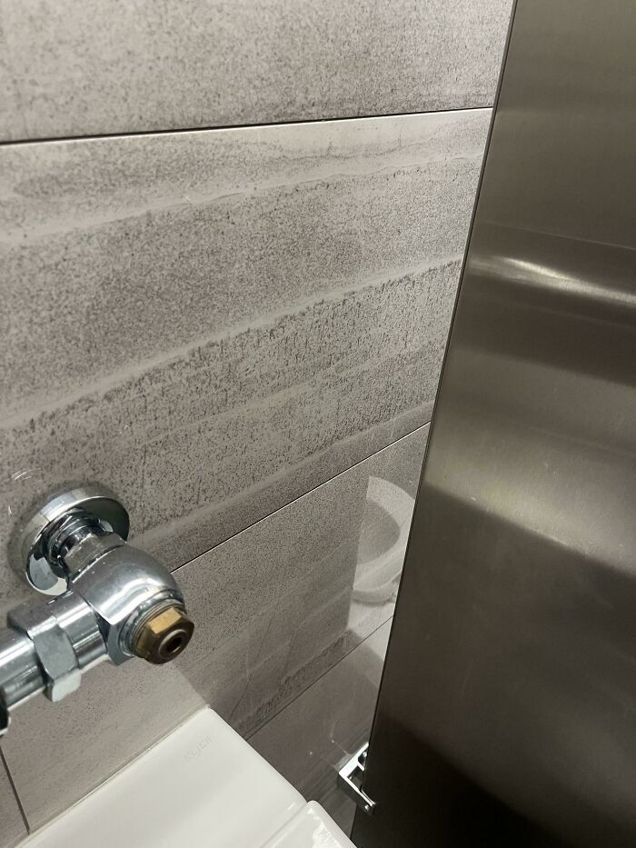 Ejemplo de fallos de diseño con una tubería instalada demasiado cerca de la pared del baño.