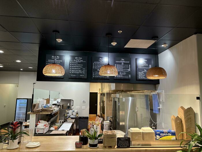 Mostrador de restaurante con lámparas desalineadas, un curioso fallo de diseño de interiores.