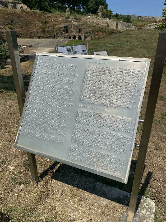 Placa informativa metálica en relieve como muestra de fallos de diseño en señalización.