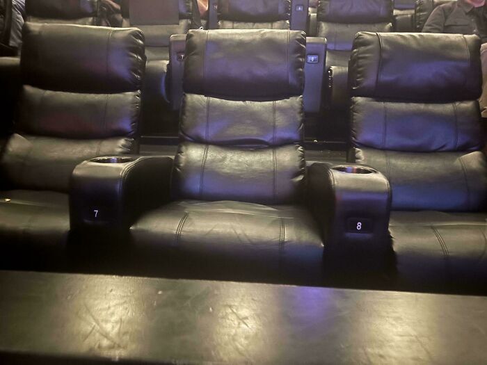Butacas de cine mal alineadas respecto a los apoyabrazos, muestra de un fallo de diseño.