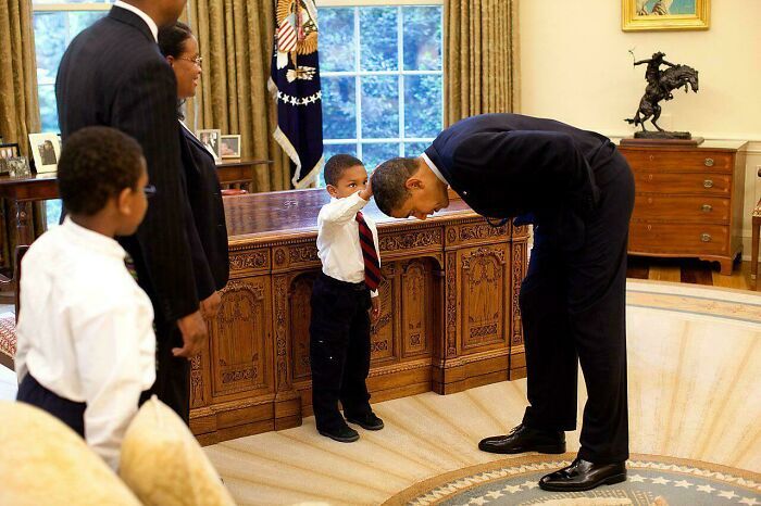 Barack Obama inclinandose ante un nino en publicaciones reconfortantes del recuerdo