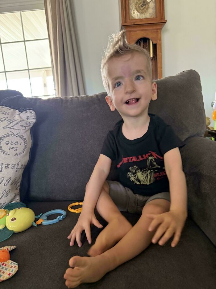Niño sonriendo sentado en un sofá, una imagen entre varias publicaciones reconfortantes que alegran el día.