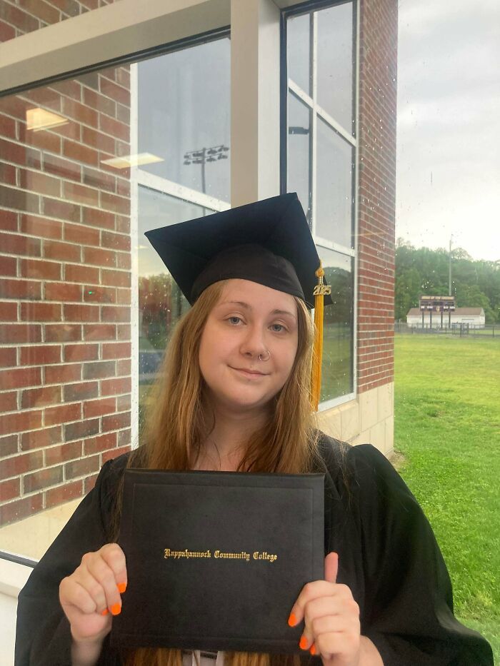 Joven posando orgullosa con su diploma tras publicaciones reconfortantes