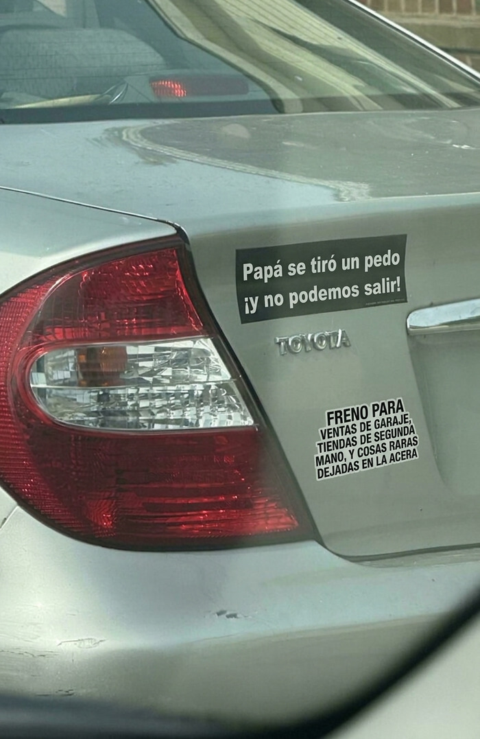 Auto gris con divertidas pegatinas en los parachoques de los coches con frases graciosas.