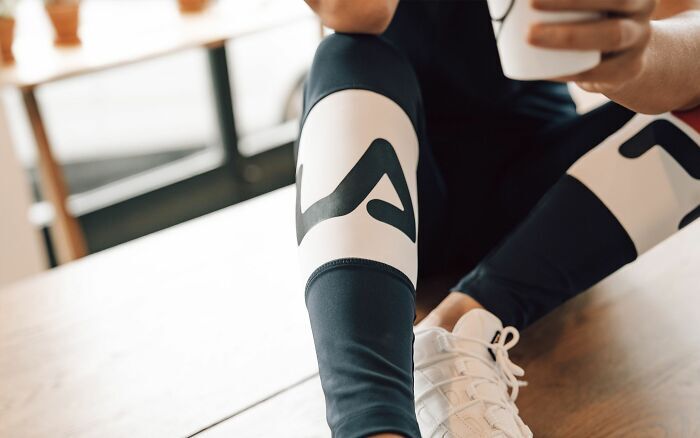 Detalle de una persona descansando en ropa deportiva en un entorno laboral tras ser despedida.