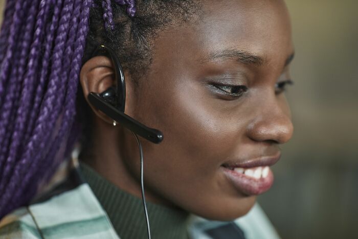 Mujer con auriculares de atención al cliente, ejemplo de trabajadores que fueron despedidos casi inmediatamente.