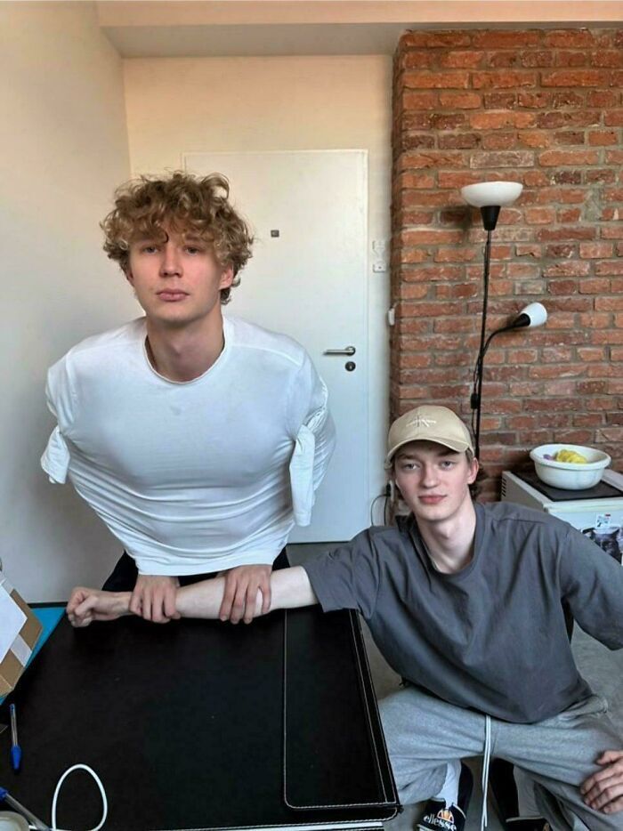 Dos hombres posando en una ilusión óptica con los brazos, creando mentiras ridiculas publicadas en internet.