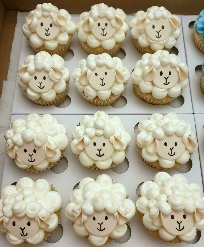 Docena de cupcakes decorados como ovejitas blancas de crema, arte en repostería creativa.