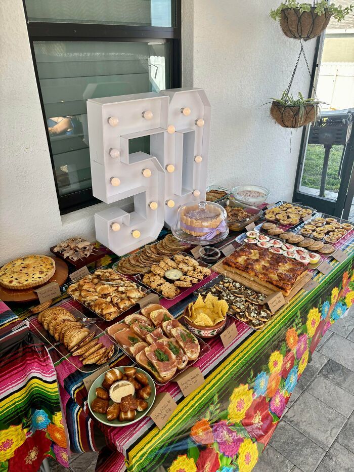 Mesa de banquete llena de aperitivos y postres para un evento, destacando el arte en la repostería.