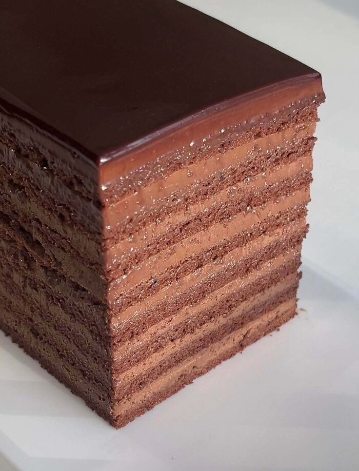 Pastel de chocolate multicapa con cobertura brillante, un ejemplo perfecto de repostería fina.
