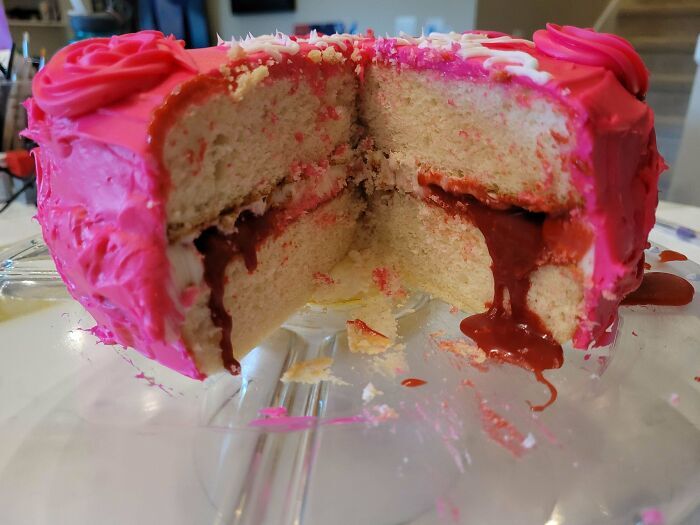 Pastel rosa cortado por la mitad con relleno rojo liquido, un ejemplo creativo de repostería.