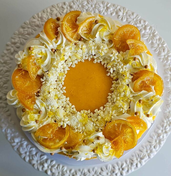 Tarta decorada con rodajas de naranja confitada, ejemplo de repostería de nivel superior.